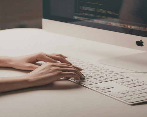 Hands typing on a keyboard with good ergonomic desk height